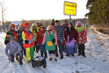 Die bunte Gesellschaft am Orteingangsschild  (Bild vergr&ouml;&szlig;ern)