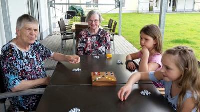 Vorschaubild: 2 Schülerinnen und 2 Bewohner beim Spielen eines Gesellschaftspiels