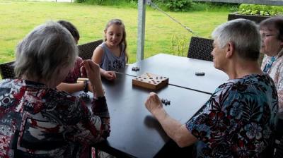 Vorschaubild: 2 Schülerinnen und 3 Bewohner beim Spielen eines Gesellschaftsspiels