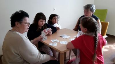 Vorschaubild: 3 Schülerinnen und 2 Bewohner beim Spielen von Karten