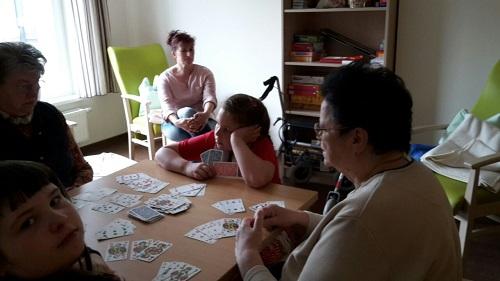 Bild: 2 Schülerinnen und 2 Bewohnerinnen beim Karten spielen, eine Frau schaut zu