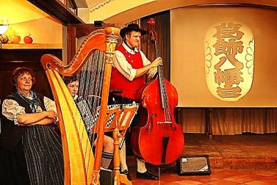 boarische Harfenmusi vor japanischen Schriftzeichen 