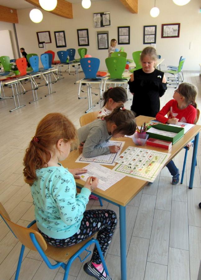 Bild: Kinder beim Spielen und Rätseln.