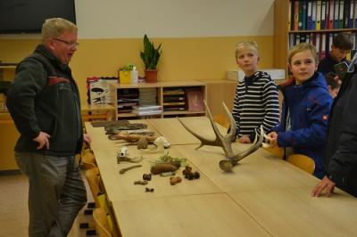Vorschaubild: Förster erklärt 2 Schülern Materialien aus dem Wald