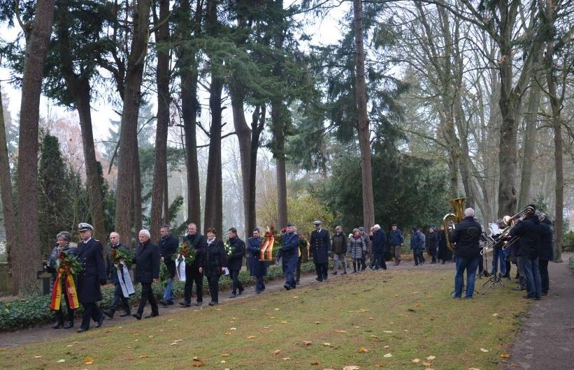 Bild: Die Teilnehmer der Gedenkveranstaltung auf dem Weg zu den Gräbern von Kriegsopfern