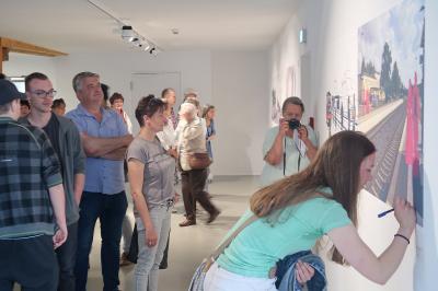 Eine junge K&uuml;nstlerin signiert ihr Werk.  (Bild vergr&ouml;&szlig;ern)