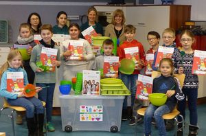 Die 3a freut sich &uuml;ber die bunten Kochger&auml;te und genauso &uuml;ber die ansprechenden Arbeitshefte. Auch auch Eltern der Sch&uuml;ler sind zur &Uuml;bergabe der Materialien gekommen, im Bild hinten mit Frau Jaques und Rektorin Andrea B&ouml;hm.  (Bild vergr&ouml;&szlig;ern)