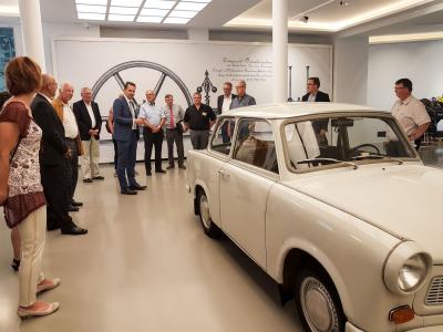 Lars Schladitz (im blauen Anzug) zeigt in der Museumsfabrik die ersten Exponate f&uuml;r die Wende-Ausstellung - unter anderem ein Trabant aus der Zeit vor 1989. Foto: Beate Vogel  (Bild vergr&ouml;&szlig;ern)