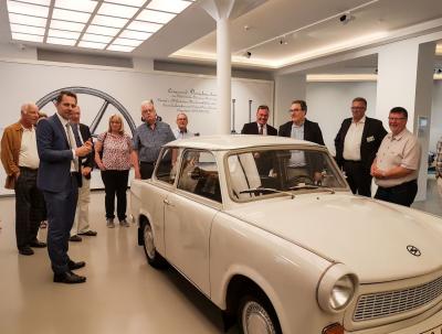 Lars Schladitz (im blauen Anzug) zeigt in der Museumsfabrik die ersten Exponate f&uuml;r die Wende-Ausstellung - unter anderem ein Trabant aus der Zeit vor 1989. Foto: Beate Vogel  (Bild vergr&ouml;&szlig;ern)