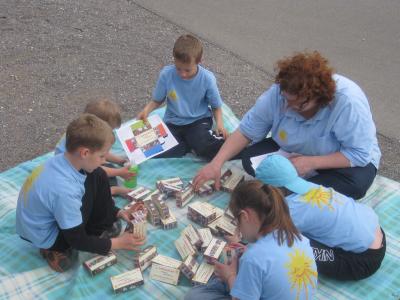Die Kinder sitzen beim Basteln gem&uuml;tlich am Streckenrand 