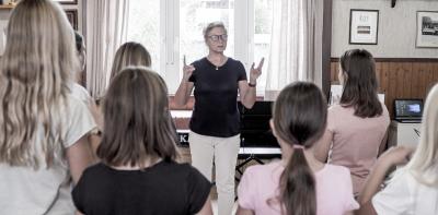 Jugendliche studieren den Text mit Renate Wagener in Geb&auml;rdensprache ein 