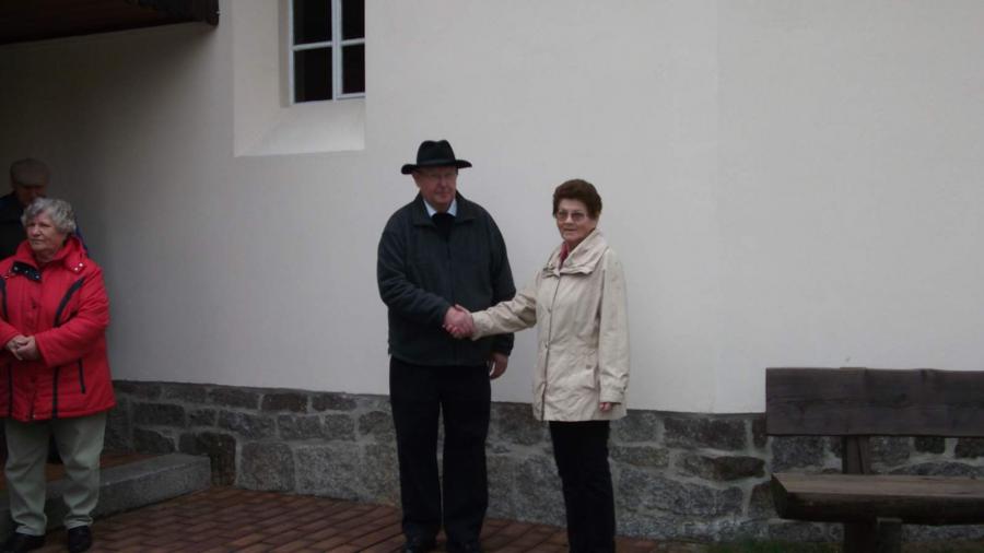 Bild: Vor dem Schulmuseum, Frau Klinkmüller begrüßt Herrn Lehmann.