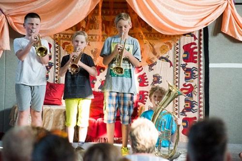 Bild: 3 Schüler trompetend, 1 Schüler mit Tuba