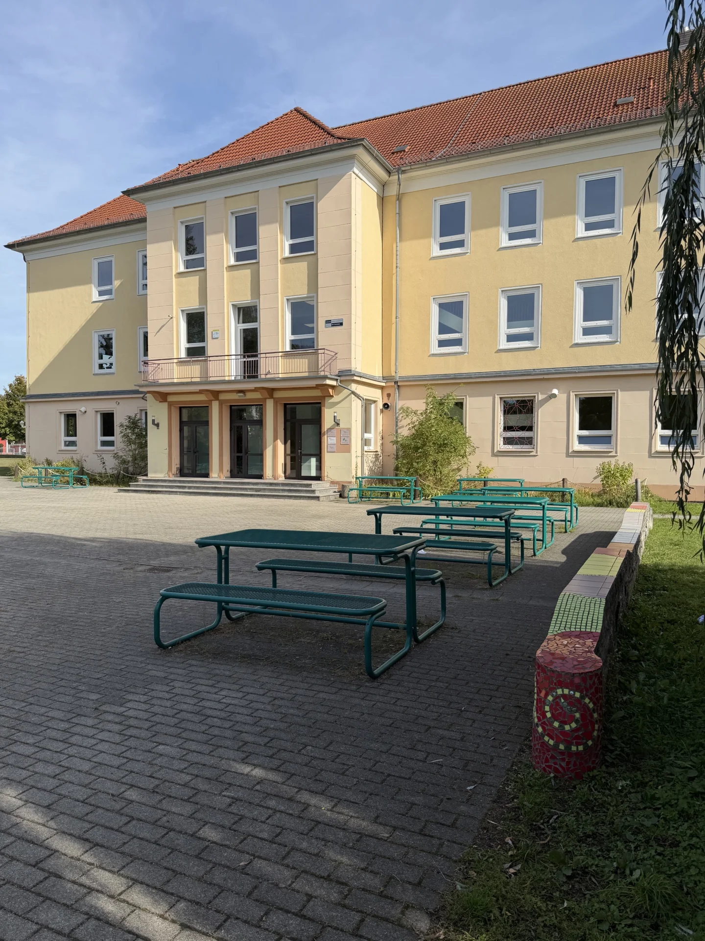 Gro&szlig;er, gr&uuml;ner Schulhof mit viel Platz zum Entspannen und Verweilen in den Pausen. 