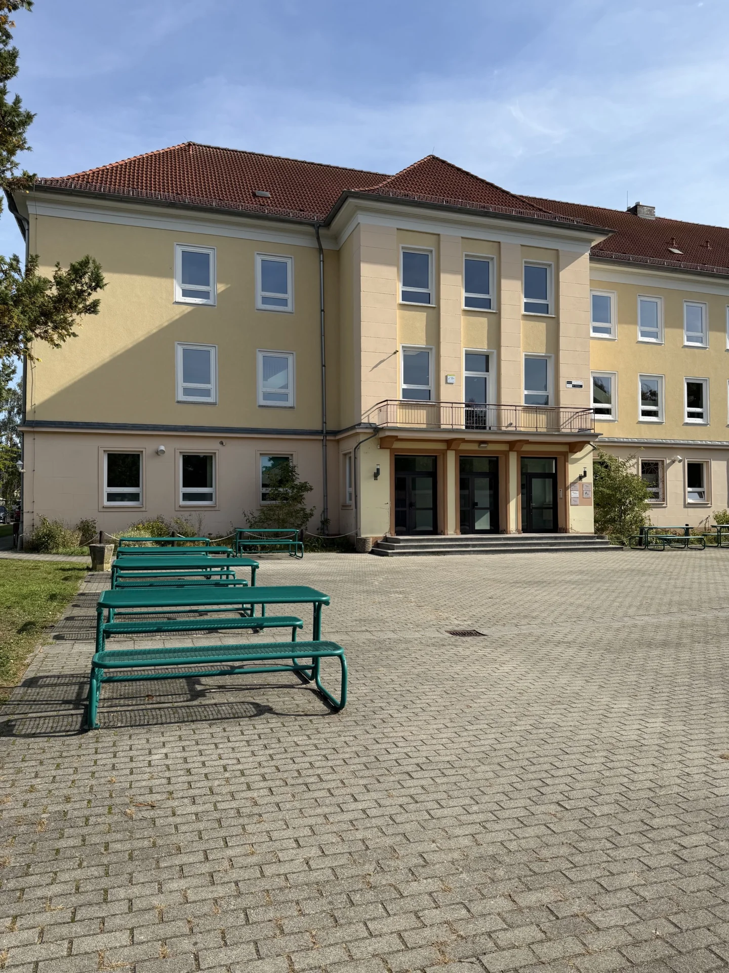 Gro&szlig;er, gr&uuml;ner Schulhof mit viel Platz zum Entspannen und Verweilen in den Pausen. 