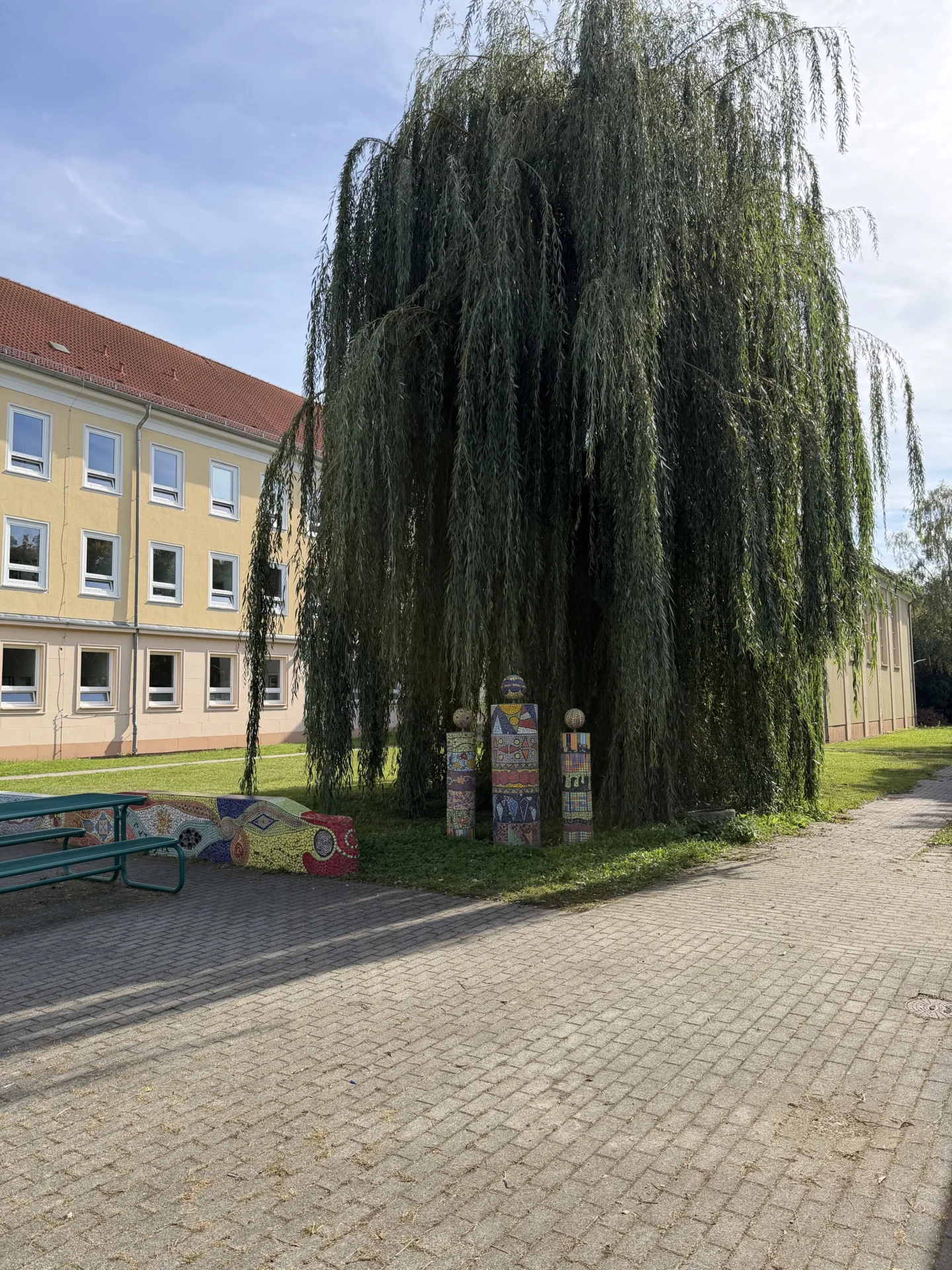 Gro&szlig;er, gr&uuml;ner Schulhof mit viel Platz zum Entspannen und Verweilen in den Pausen. 