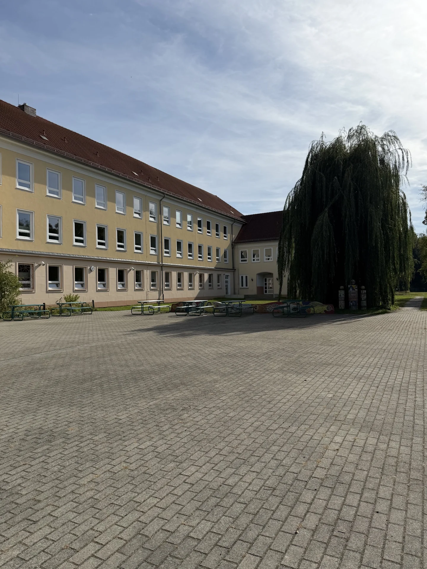 Gro&szlig;er, gr&uuml;ner Schulhof mit viel Platz zum Entspannen und Verweilen in den Pausen. 