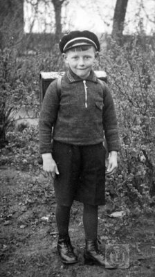Vorschaubild: Reinhard Buß mit Schirmmütze, Tornister und typischer kurzer Hose an seinem ersten Schultag 1937 in Holterfehn-Holtermoor. Foto überlassen von Johanne Buß (Repro: Groeneveld).