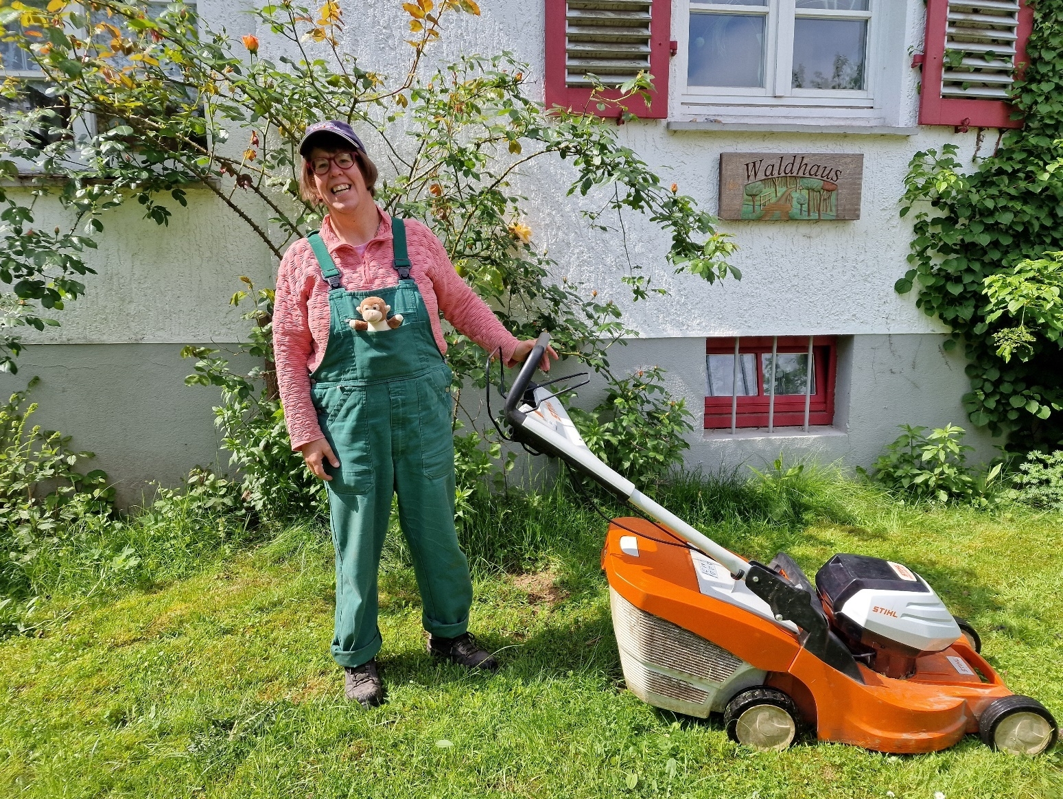 Bild: Person mit Rasenmäher