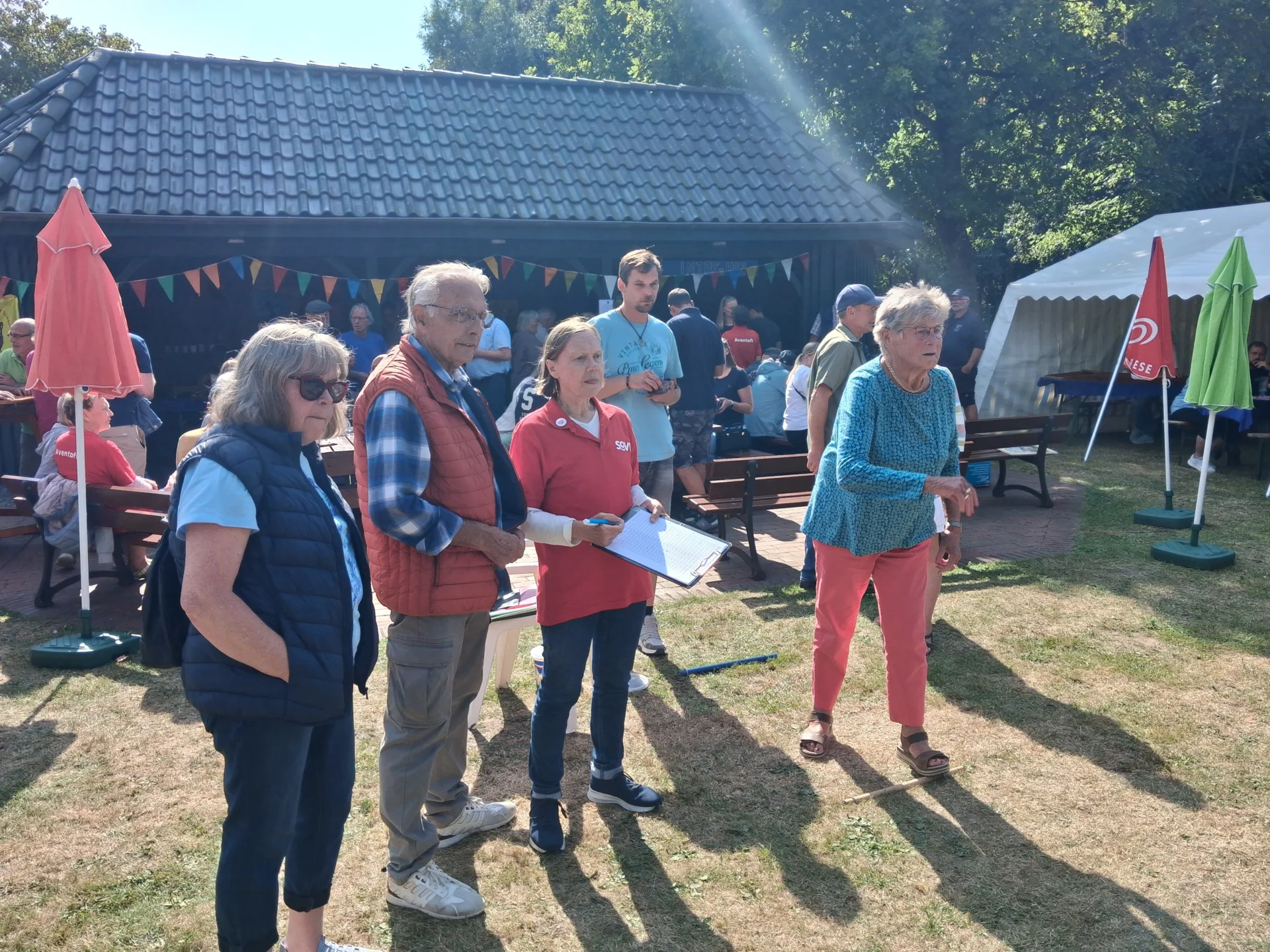 Bild: 15.08.26 - Ein fröhliches Dorffest mit vielen Attraktionen für alle Altersgruppen feierte die Gemeinde Aventoft mit Unterstützung der örtlichen Vereine im idyllischen „Dres-Park-Stadion“. Und dieses wurde von der Dorfbevölkerung mit einem regen Besuch dankbar angenommen, darunter auch zahlreiche ehemalige Aventofter und auch Neubürger. Die Freiwillige Feuerwehr bot eine reichliche Tombola an und war für die kühlen Getränke zuständig. Bei der „Wilderei“ gab es leckere Bratwurst und Steaks vom Wildschwein, während die Hobbyfußballer von „Inter“ ihre berühmten Pommes anboten. Beim in Aventoft beheimatete Luftsportverein Südtondern konnte mit Segelflug-Simulatoren „geflogen“ werden. Mit dabei natürlich auch der SoVD Ortsverband. Die stellvertretende Vorsitzende Maren Christiansen organisierte ein leckeres Kuchenbüfett mit vielen gespendeten Backwerken von der Dorfbevölkerung. Bei Jugendsprecherin Manuela Nielsen konnte ein Jeder an der Buttonmaschine kreativ werden. Ulla Jördens, stellvertretende Frauensprecherin, war für das beliebte Sackwerfen zuständig.