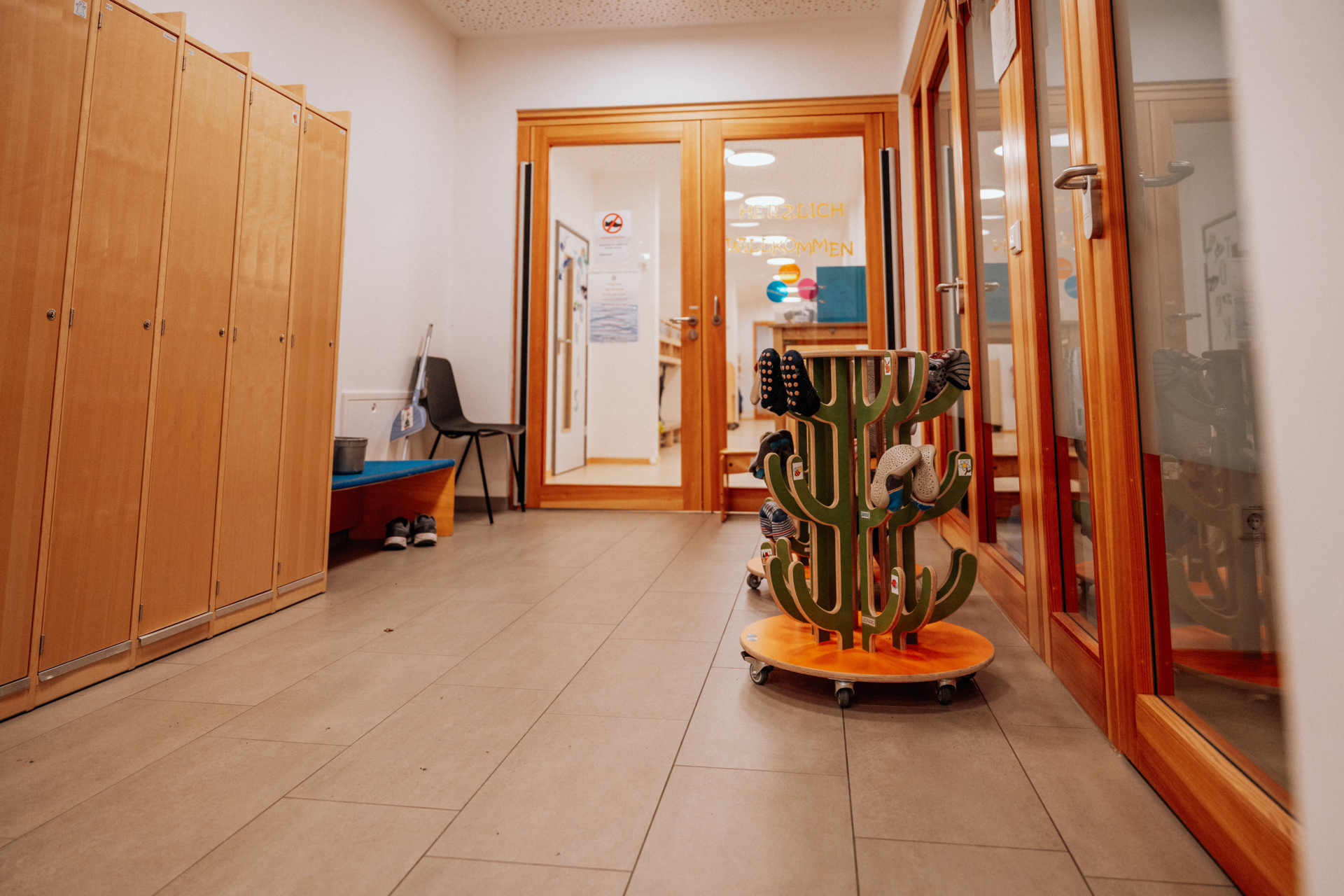 Foyer: Da in unserem Kleinkindbereich keine Stra&szlig;enschuhe getragen werden d&uuml;rfen hat hier jedes Kind einen Platz f&uuml;r die Schuhe bzw. Hausschuhe am Schuhkaktus. F&uuml;r Eltern und Besucher liegen &Uuml;berzieher bereit.  (Bild vergr&ouml;&szlig;ern)