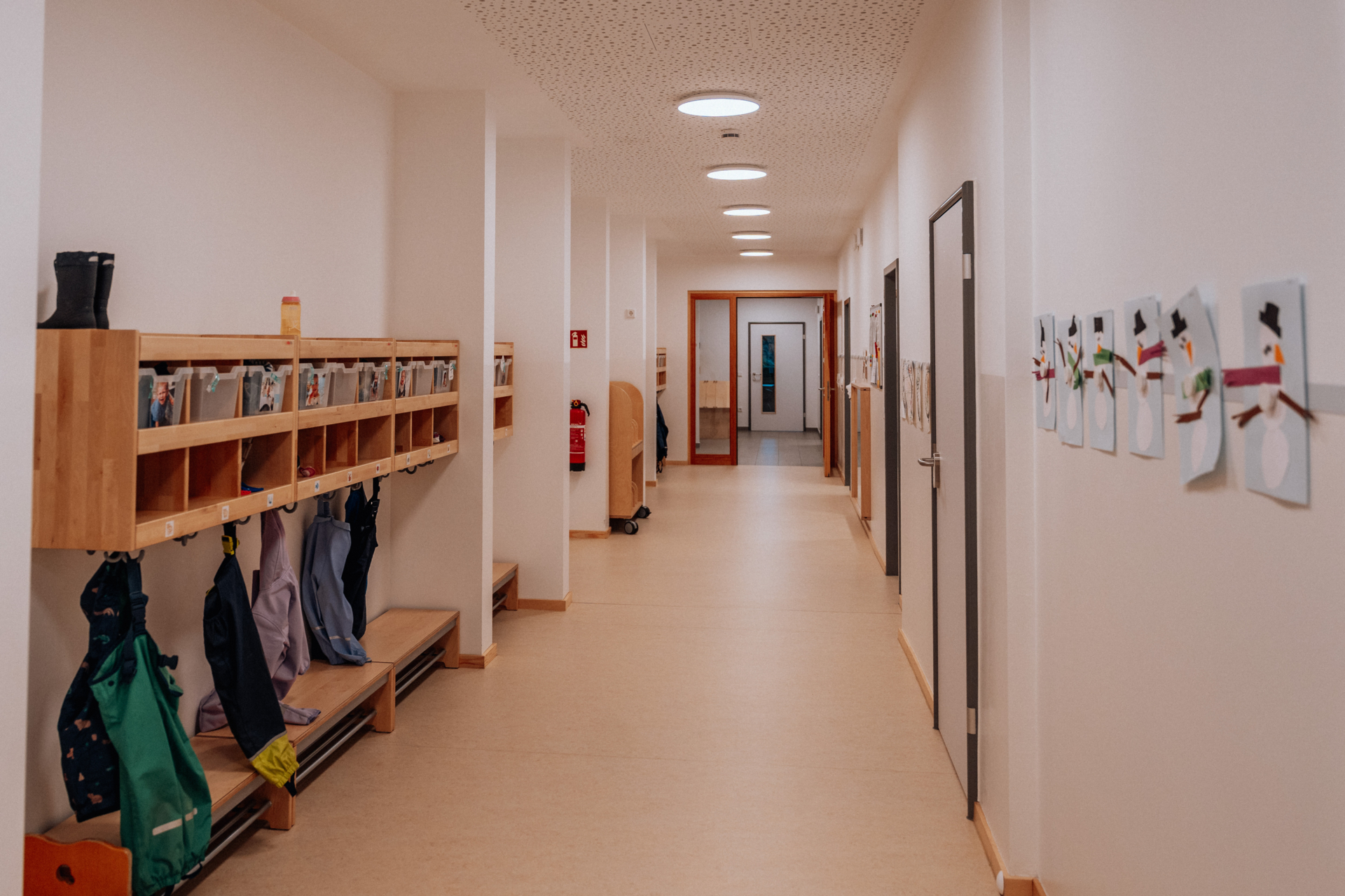 In unserem Flur hat jedes Kind einen Garderobenplatz f&uuml;r Jacken, M&uuml;tzen usw. Dieser Bereich wird unter dem Tag auch zum Spielen genutzt, z. B. Rennen, spezielle Spielangebote f&uuml;r die &auml;lteren Kinder der Gruppe, R&auml;dchen fahren.  (Bild vergr&ouml;&szlig;ern)