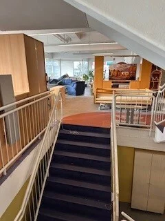 Foto: Eine Treppe f&uuml;hrt eine Etage h&ouml;her. Hier stehen Betten und Sofas.  (Bild vergr&ouml;&szlig;ern)