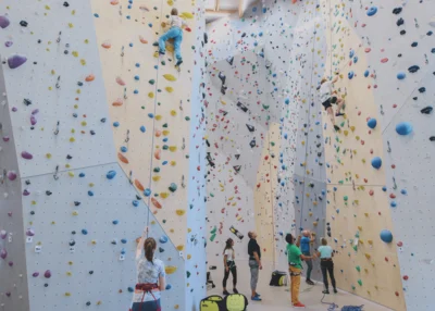 Vorschaubild: Kletterhalle in der zahlreiche Personen klettern und sichern