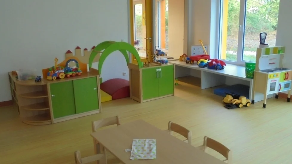 Bild: Im Kreativraum sind Mal- und Bastelsachen, sowie Materialien zum Experimentieren und Arbeiten mit Zahlen und Mengen zu finden. In einem geordneten Flachstreckensystem bekommen die Kinder schnell einen Überblick über die Dinge, die sie nutzen können. Die Tischgruppen bieten den Kindern genügend Raum, sich kreativ zu betätigen. Die Resultate ihres kreativen Schaffens können hier gelagert werden bis klar ist, wohin das Kind es haben möchte. (Portfolio, nach Hause, ausgestellt, Eigentumsfach).