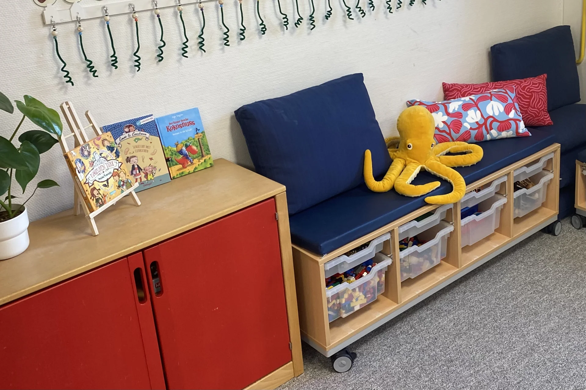 Kuschelecke der Klasse 1 mit Ottilie Oktopus &ndash; ein gem&uuml;tlicher R&uuml;ckzugsort mit vielen Kissen, B&uuml;chern und Spielzeug zum Entspannen und Wohlf&uuml;hlen. 