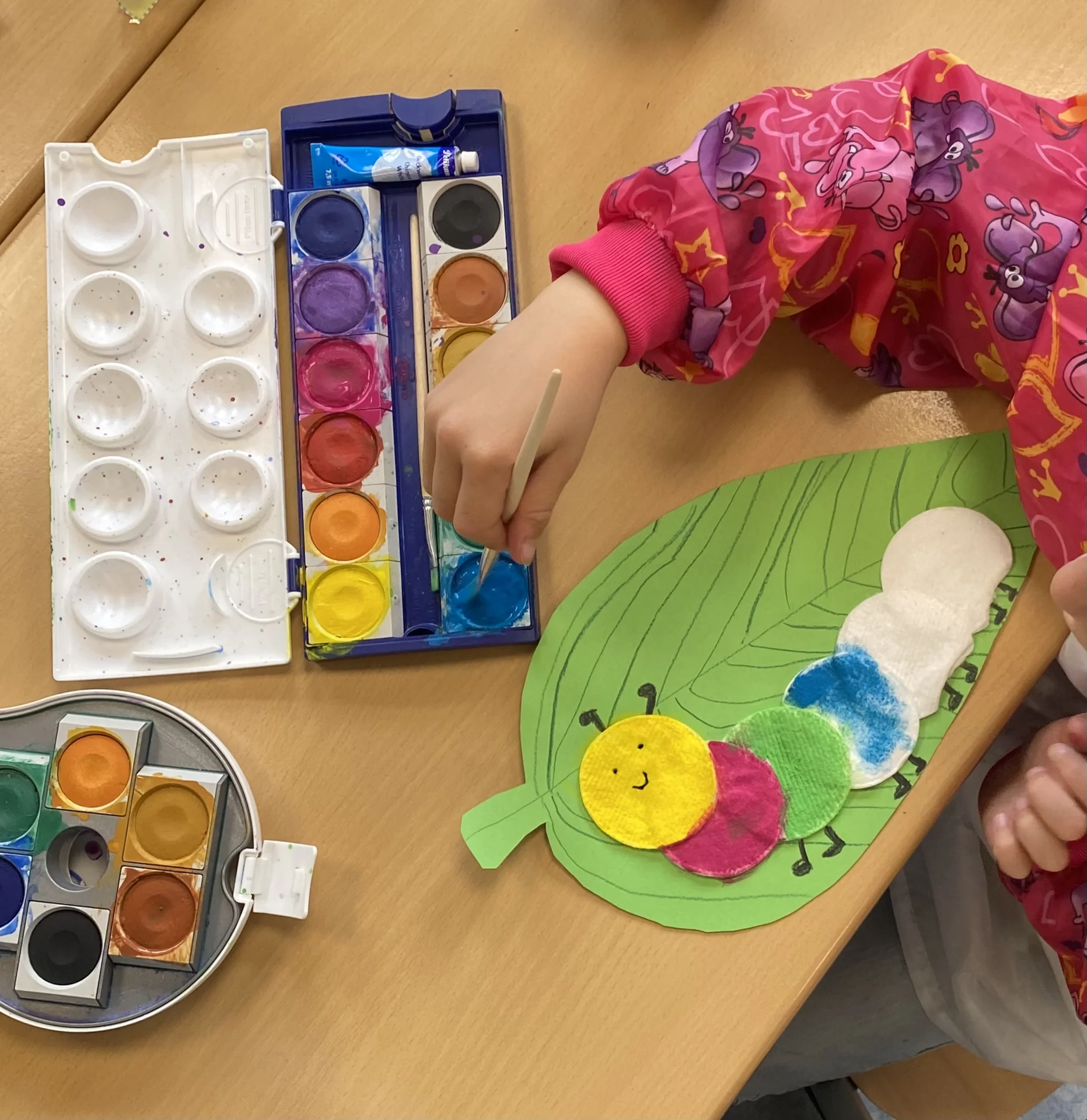 Klasse 1 gestaltet im Kunstunterricht kunterbunte Raupen mit Wasserfarben auf Watte. 