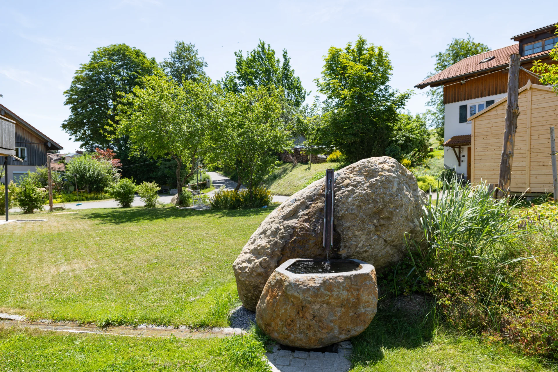 Steinbrunnen mit Blick auf den Garten  (Bild vergr&ouml;&szlig;ern)