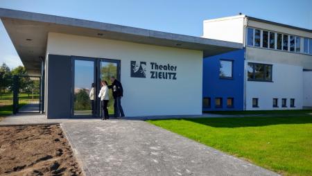 Foto: Eingang zum Theatergebäude von Zielitz. Hier spielt das Holzhaustheater Komödien und Märchen. 