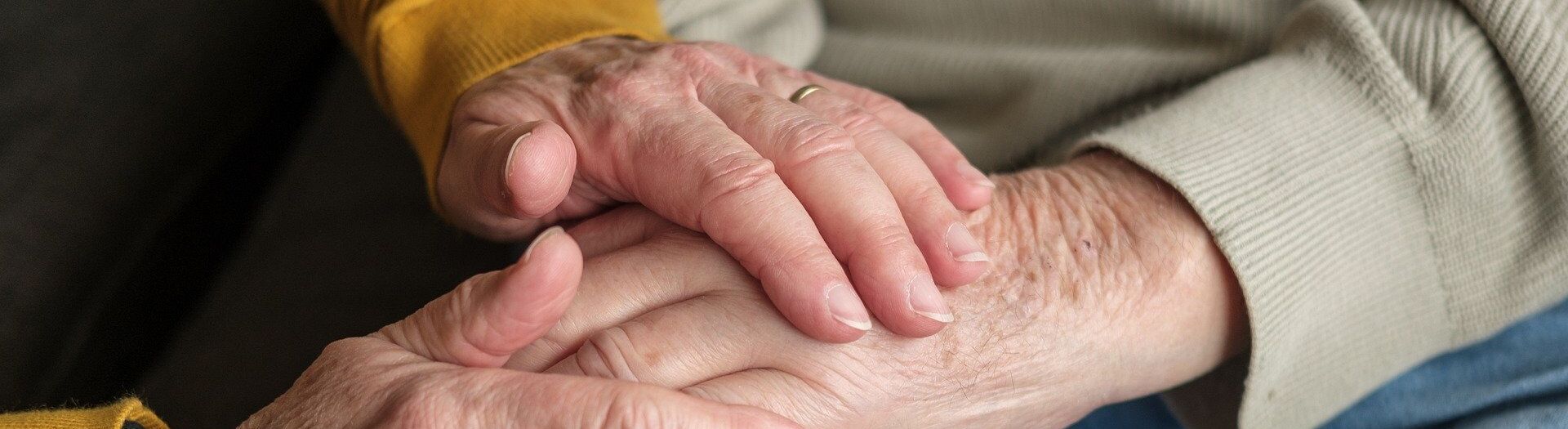 Die Hände einer Person greifen nach einer Hand einer weiteren Person