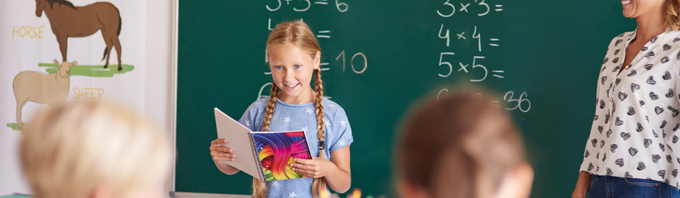 Mädchen ließt vor der Klasse