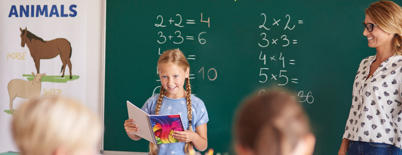 Mädchen ließt vor der Klasse
