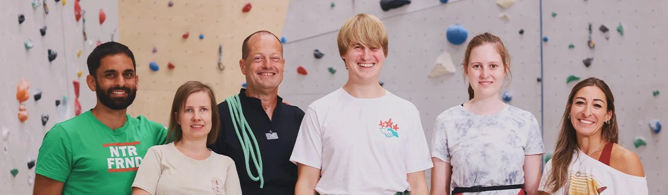 Sechs Personen vor einer Kletterwand
