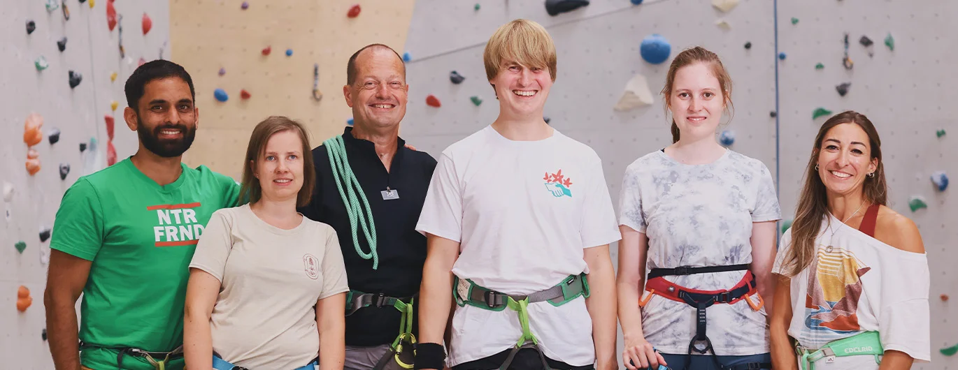 Sechs Personen vor einer Kletterwand
