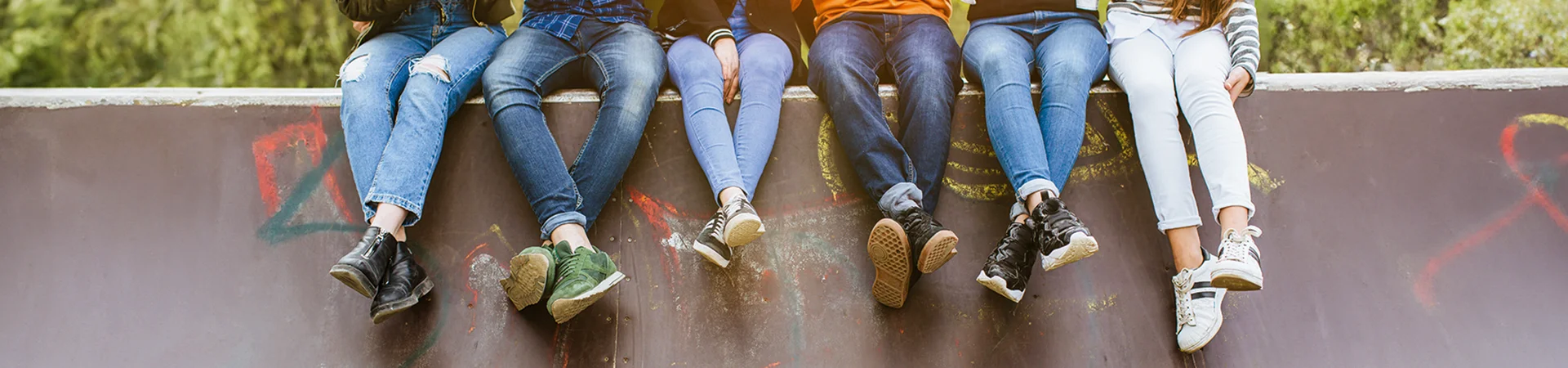 Jugendliche sitzen auf Mauer