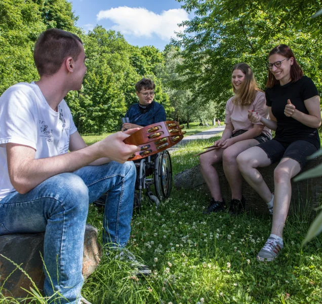Vier Personen im Park halten Muskinstrumente