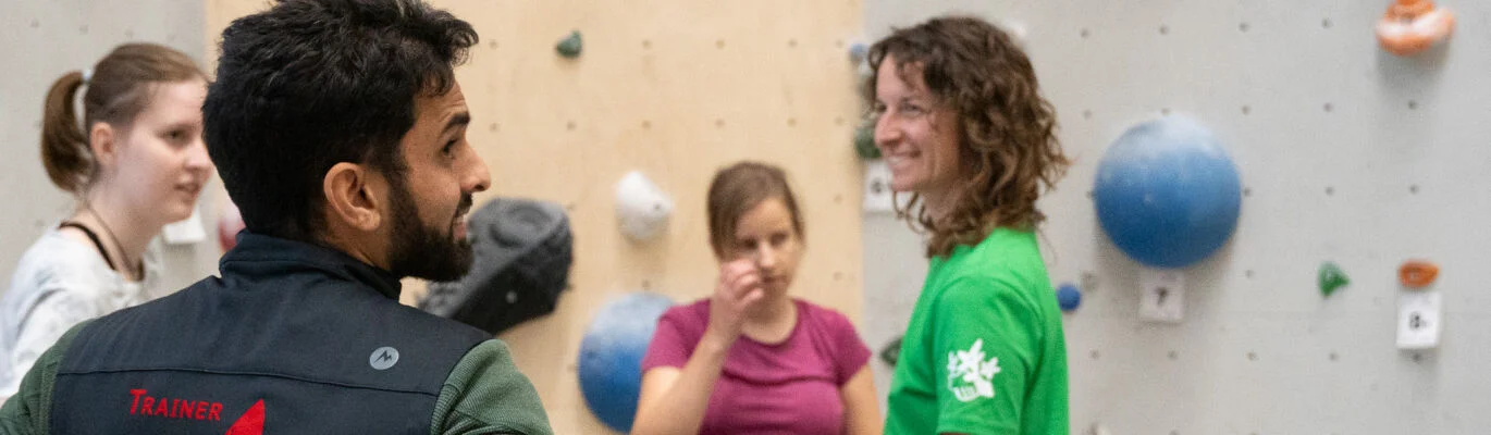 4 Personen vor einer Kletterwand