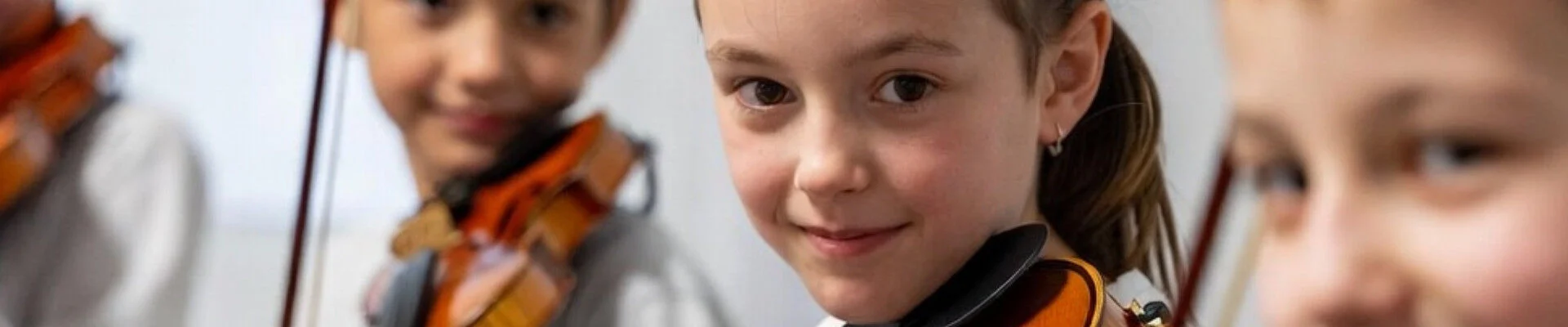 Kinder mit Violinen in einem Orchester (KI-generiert)