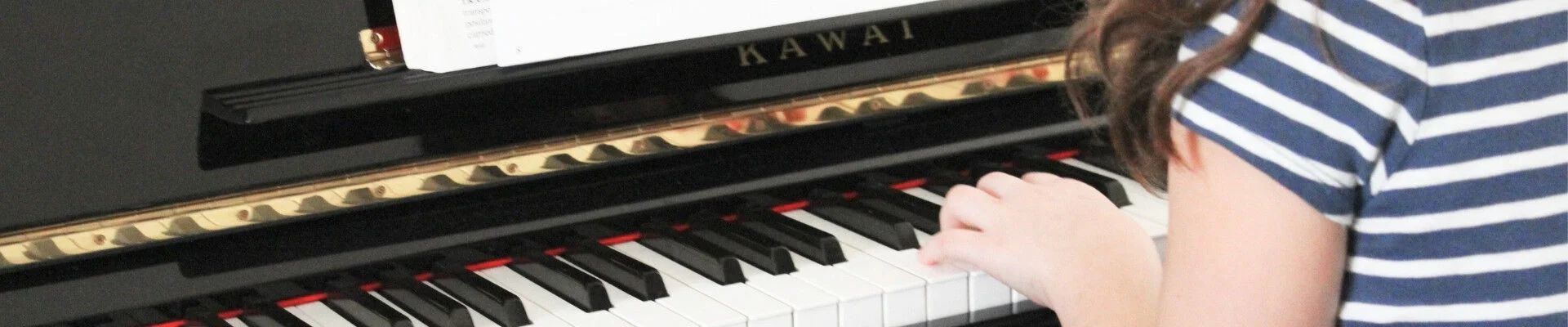Kind an einem Klavier von hinten (KI-generiert)