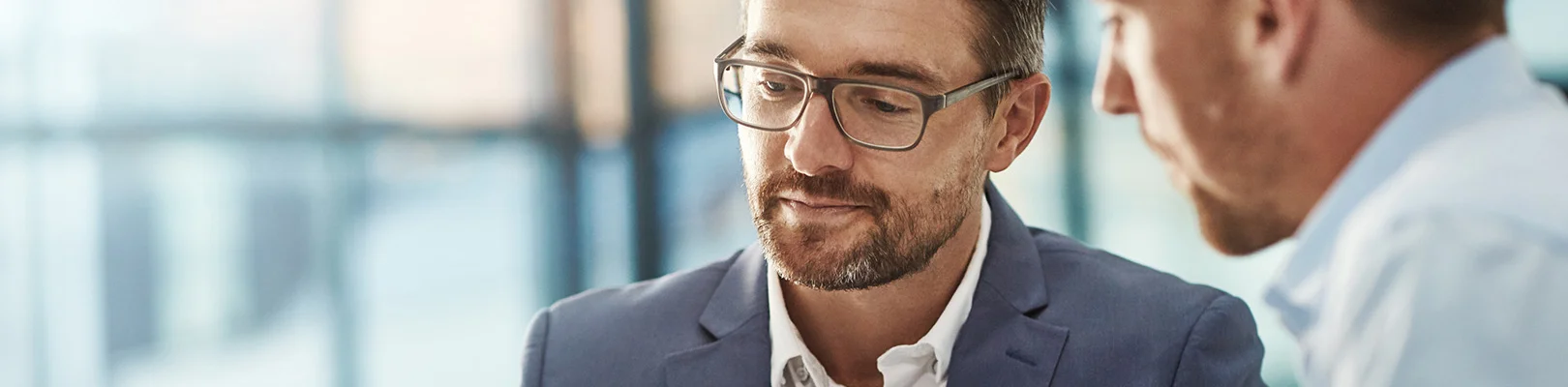 Zwei Männer sitzen  in einem Meeting und besprechen sich