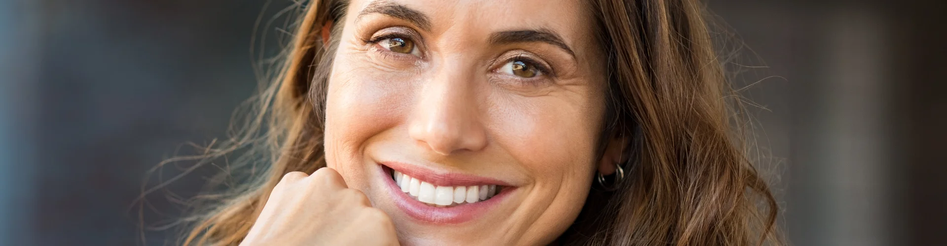 Lächelnde Frau im Banner der Hormonsprechstunde für bioidentische Hormone