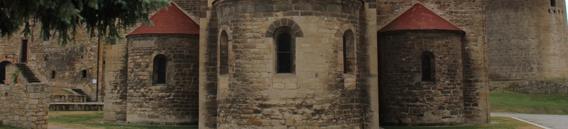 Sandsteingebäude mit drei Rundungen, den Apsiden einer Kirche im romanischen Baustil