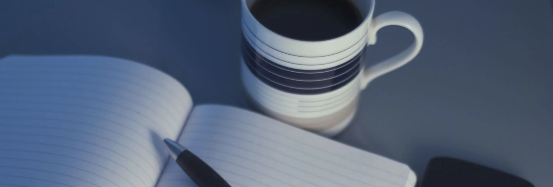 aufgeschlagenes Buch mit Kaffeetasse