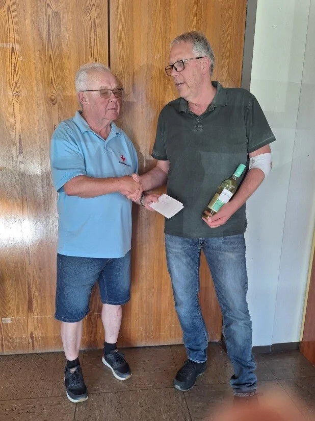 Klaus Boländer (rechts) wird für seine 100. Blutspende geehrt und das Vereinsmitglied Walter Hellwig überreicht ihm zum Dank ein Präsent vom DRK Ortsverein Kirchheim