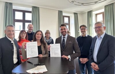 Tanja Hauck, Koordinatorin des Versorgungsnetzwerks Hospiz- und Palliativregion Traunstein, und Landrat Siegfried Walch zeigen die „Charta zur Betreuung schwerstkranker und sterbender Menschen in Deutschland“ im Kreis der Gründungsmitglieder der Hospiz- und Palliativregion Traunstein. − Foto: Landratsamt (Bild vergrößern)