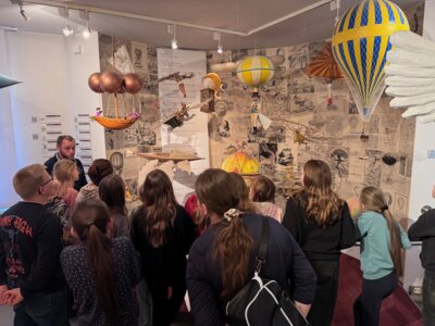 Museumsleiter Dr. Peter Busse (links hinten) zeigte und erzählte den Jarmener Grundschülern allerlei Spannendes über die Anfänge der Fliegerei. (Foto: Schreiber)